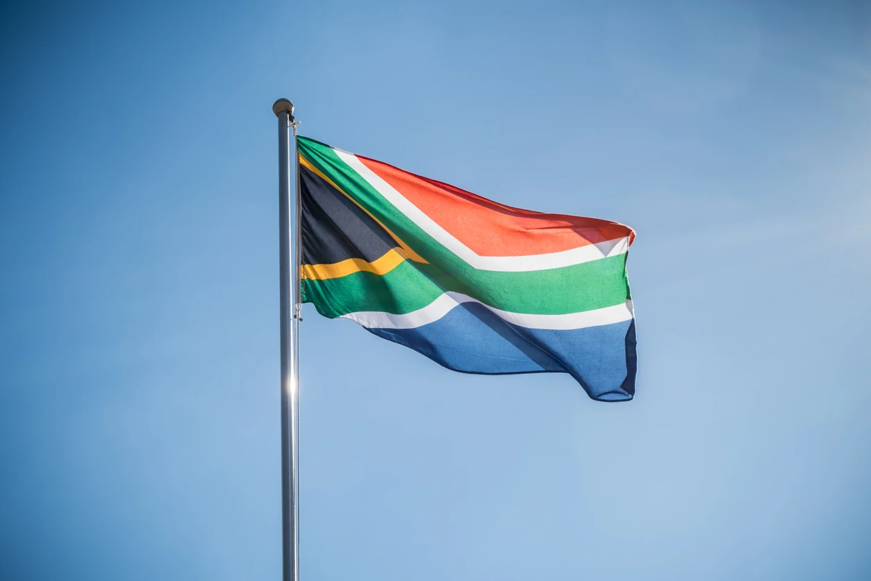 Flag of South Africa against blue sky. Landscape exterior.