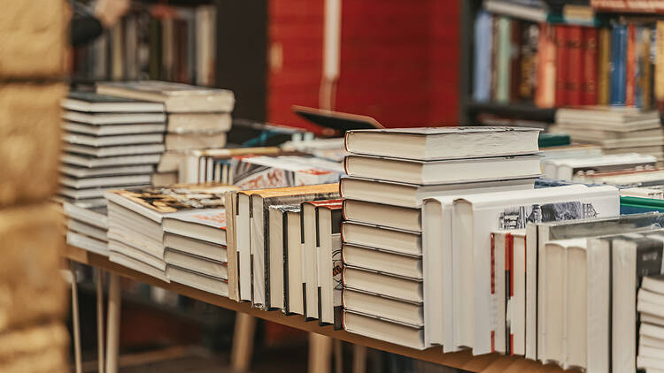 Stacks of hardcover books displayed on bookstore tables during busy literary season Stacks of hardcover books displayed on bookstore tables during busy literary season. Bookstore atmosphere evokes passion, curiosity and timeless love for books