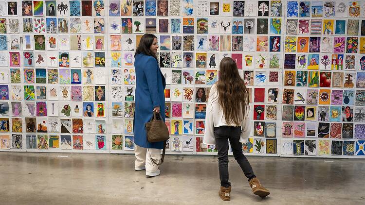 Incognito Art Show woman and girl looking at artworks at Incognito Art Show