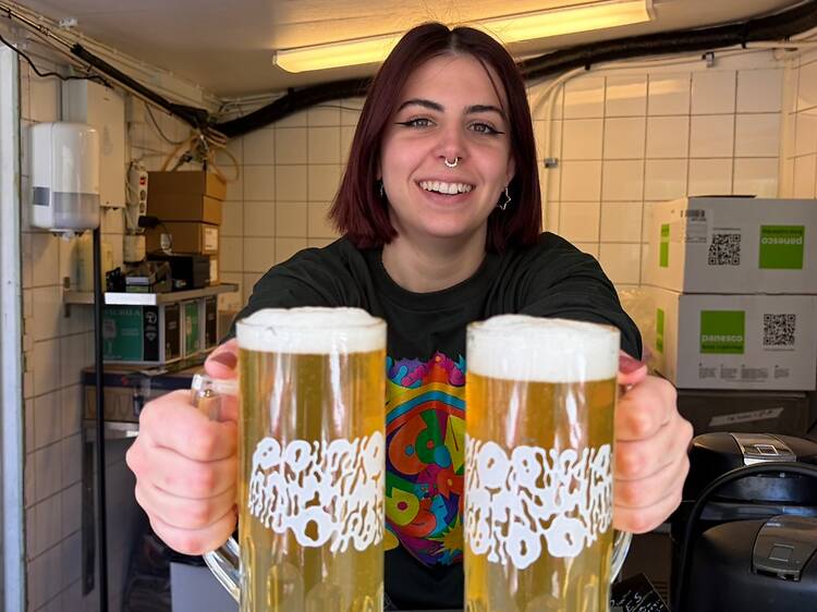 Happy girl with beers in omnipollo humlegården beer garden. Happy girl with beers in omnipollo humlegården beer garden.