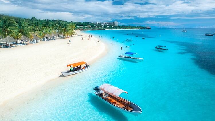 Aerial view of the boats on tropical sea coast with white sandy beach on summer sunny day in Kendwa, Zanzibar