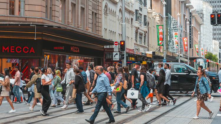 Queen Victoria Building a crowd of people walking on a street