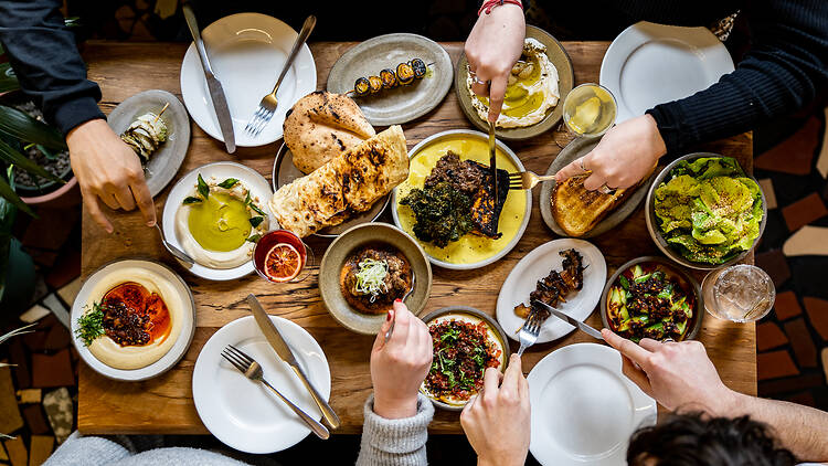 Hands reaching to grab a forkful of food from Bubala's vegetarian sharing plates Hands reaching to grab a forkful of food from Bubala's vegetarian sharing plates