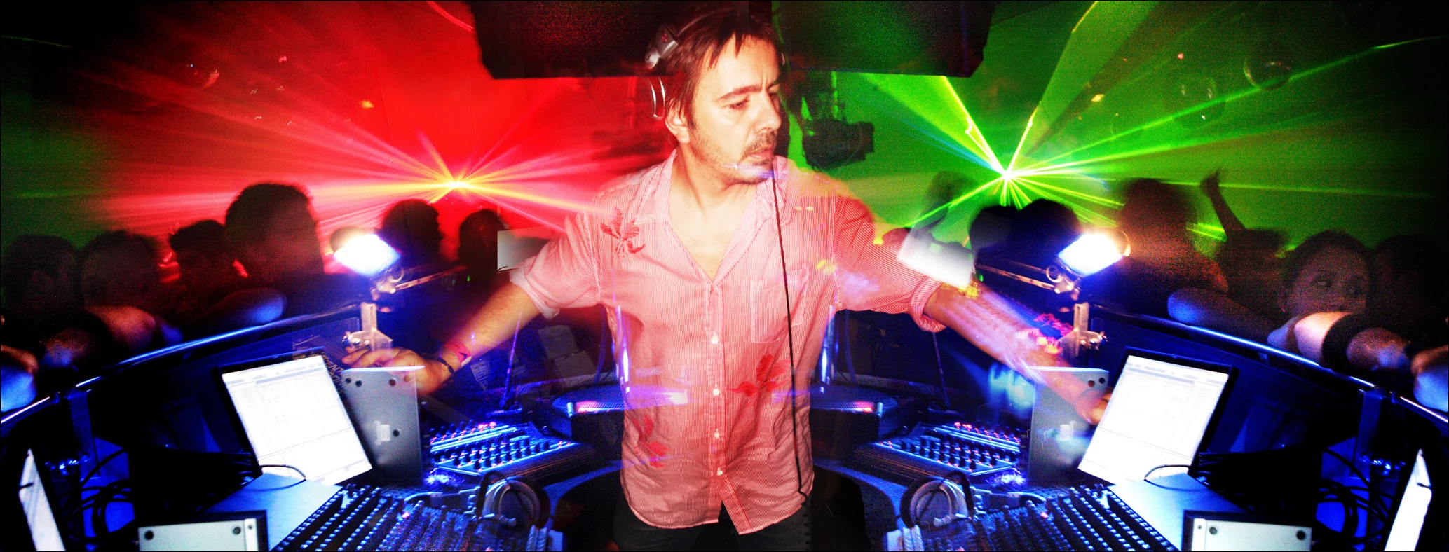 A DJ in a booth surrounded by clubbers and bright green and red lights at The End&rsquo;s 10th anniversary party
