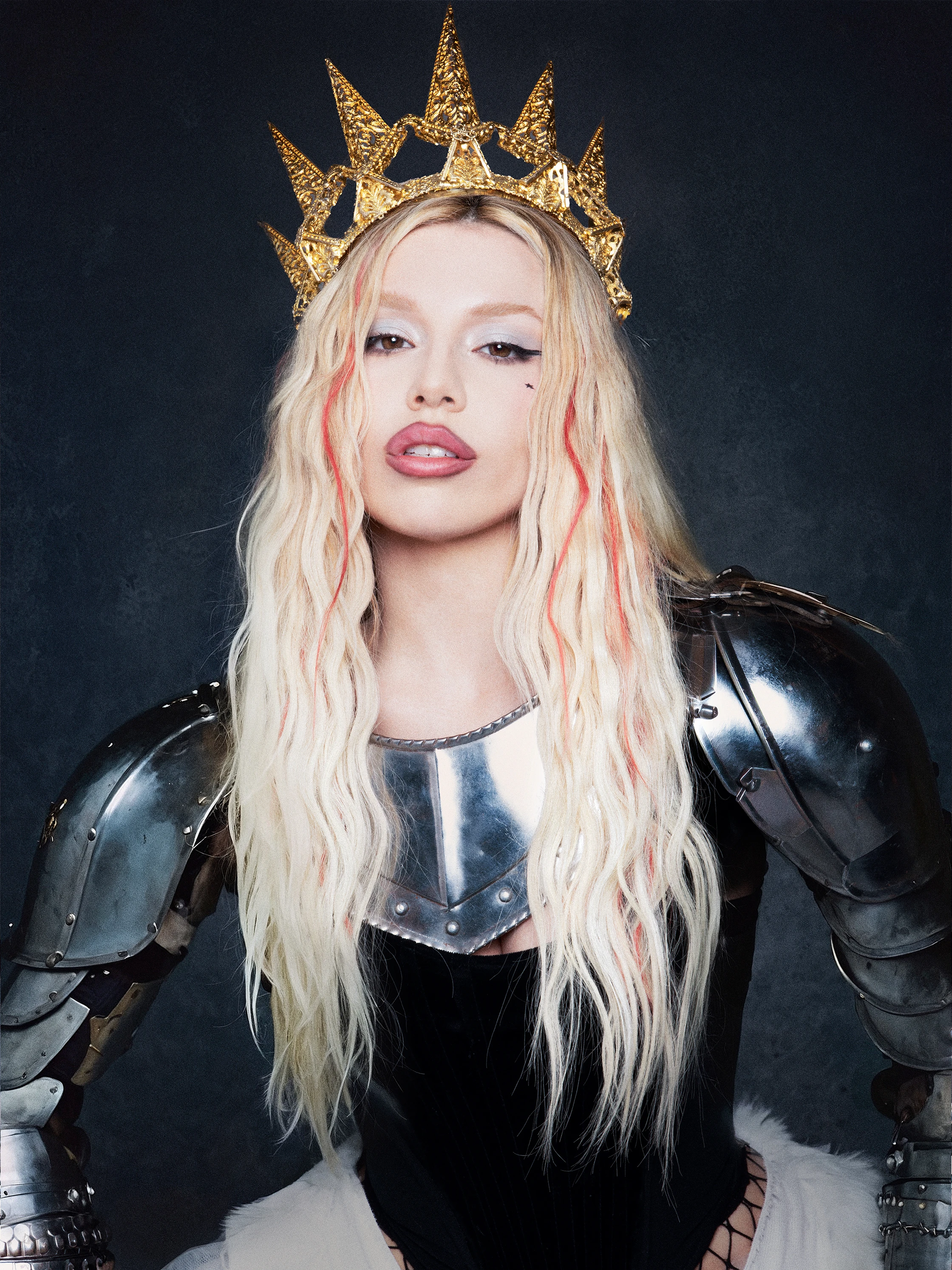Ava Max in armor and wearing a gold crown.