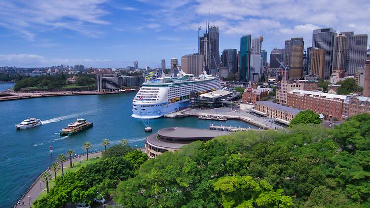 a cruise ship docked in a harbour with a city in the background