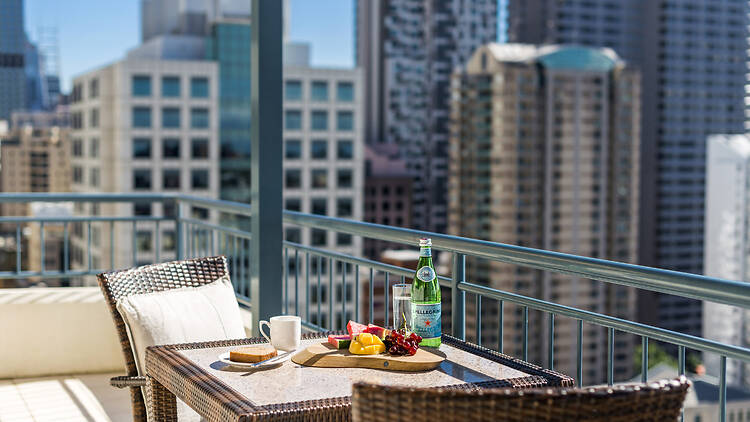 A hotel balcony with city views and breakfast in the sun