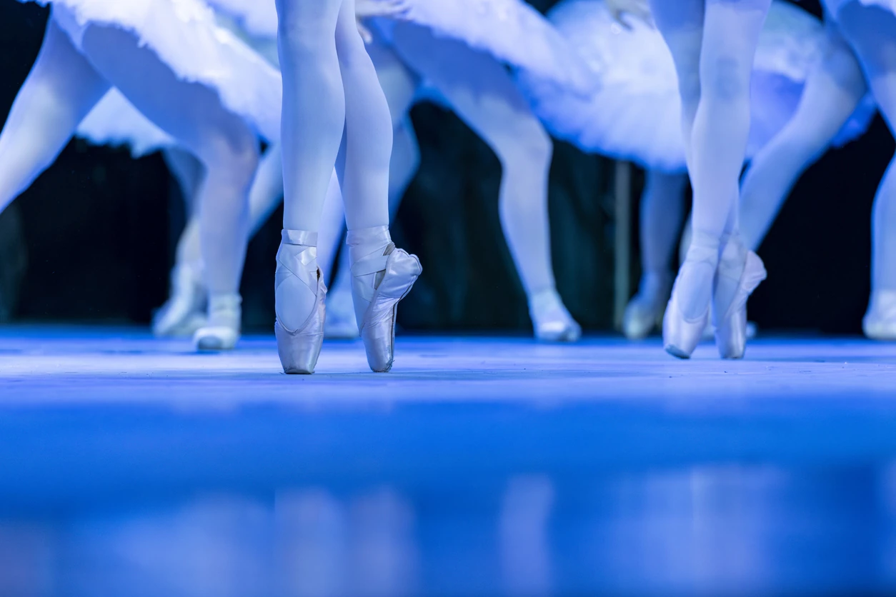 Shot of a group of ballerinas standing in a row with their feet "en pointe" - stock photo