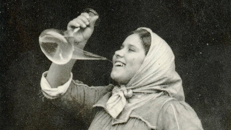 Una noia bevent vi blanc a galet amb un porró, a finals del s. XIX. Una noia bevent vi blanc a galet amb un porró, a finals del s. XIX.
