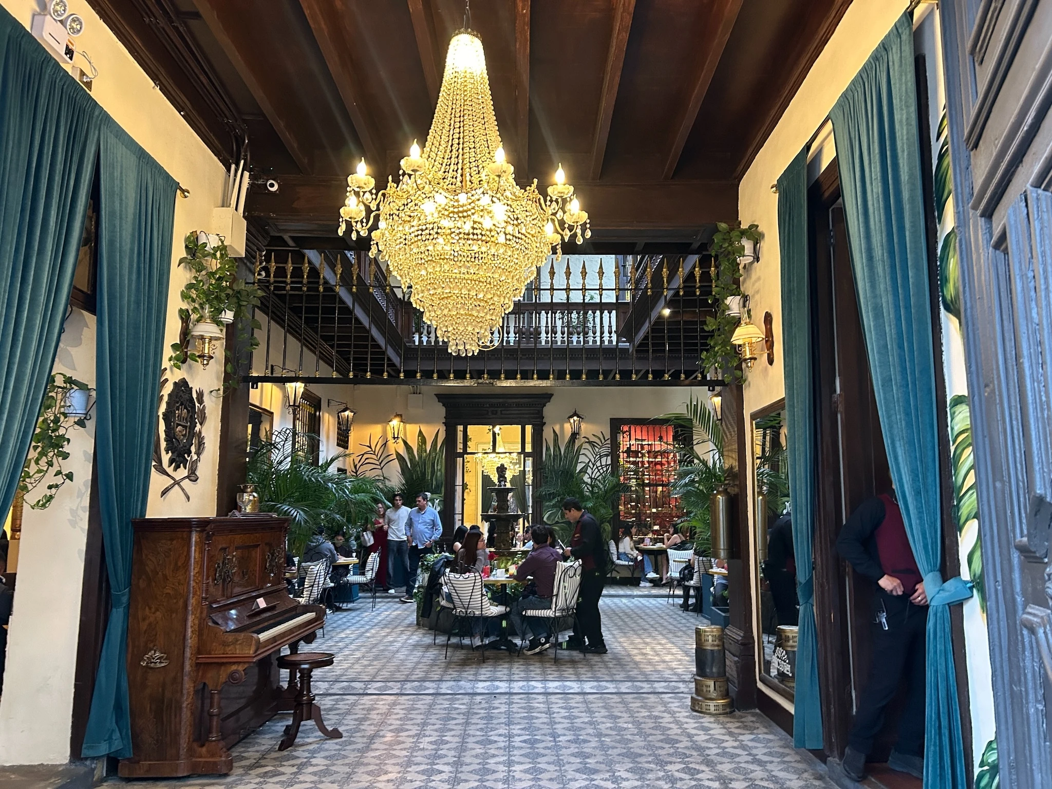 A restaurant in Lima with people eating under a chandelier