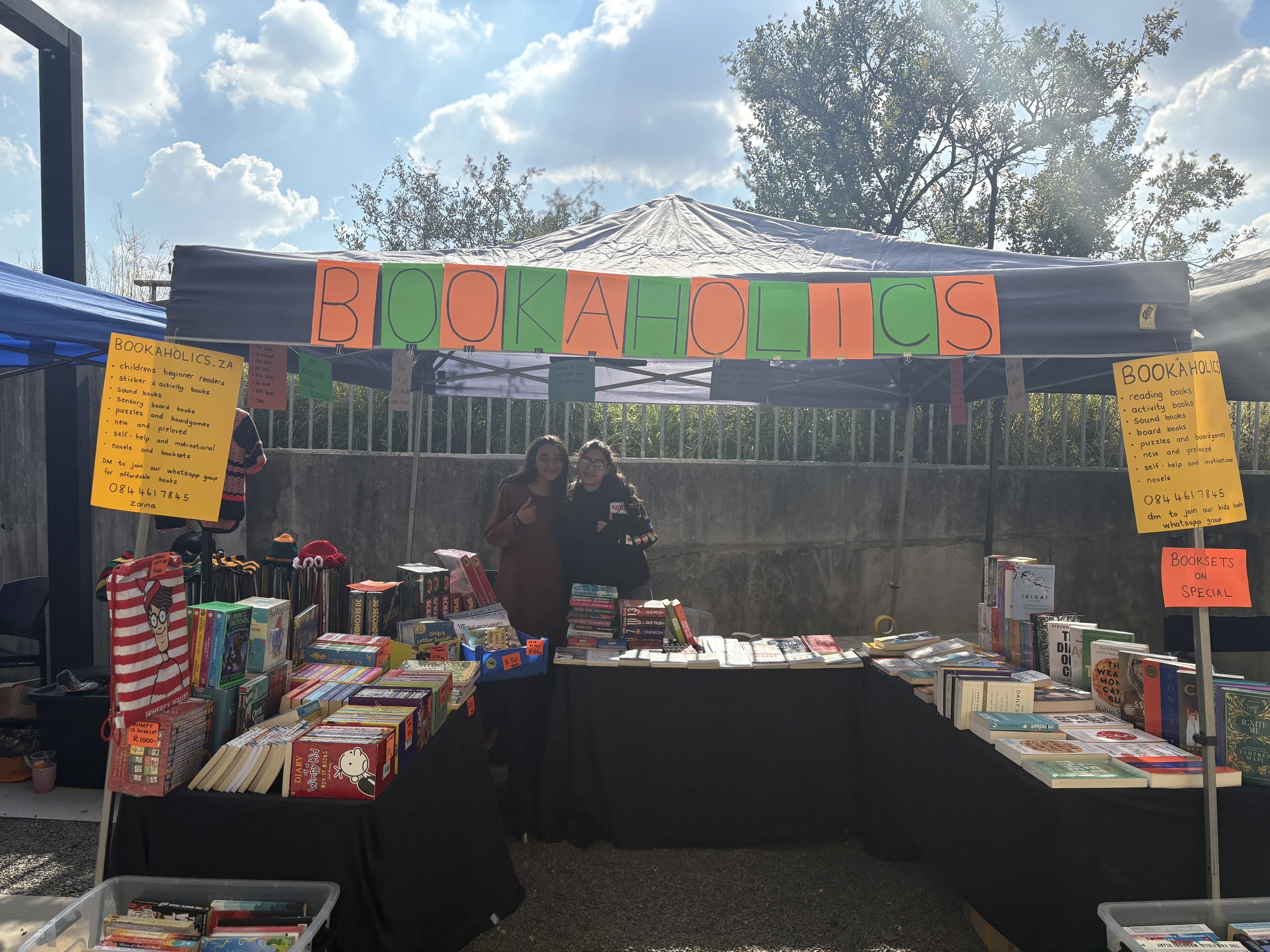 Habiba Yousuf and Zainab Asif standing behind their table at Bookaholics stall