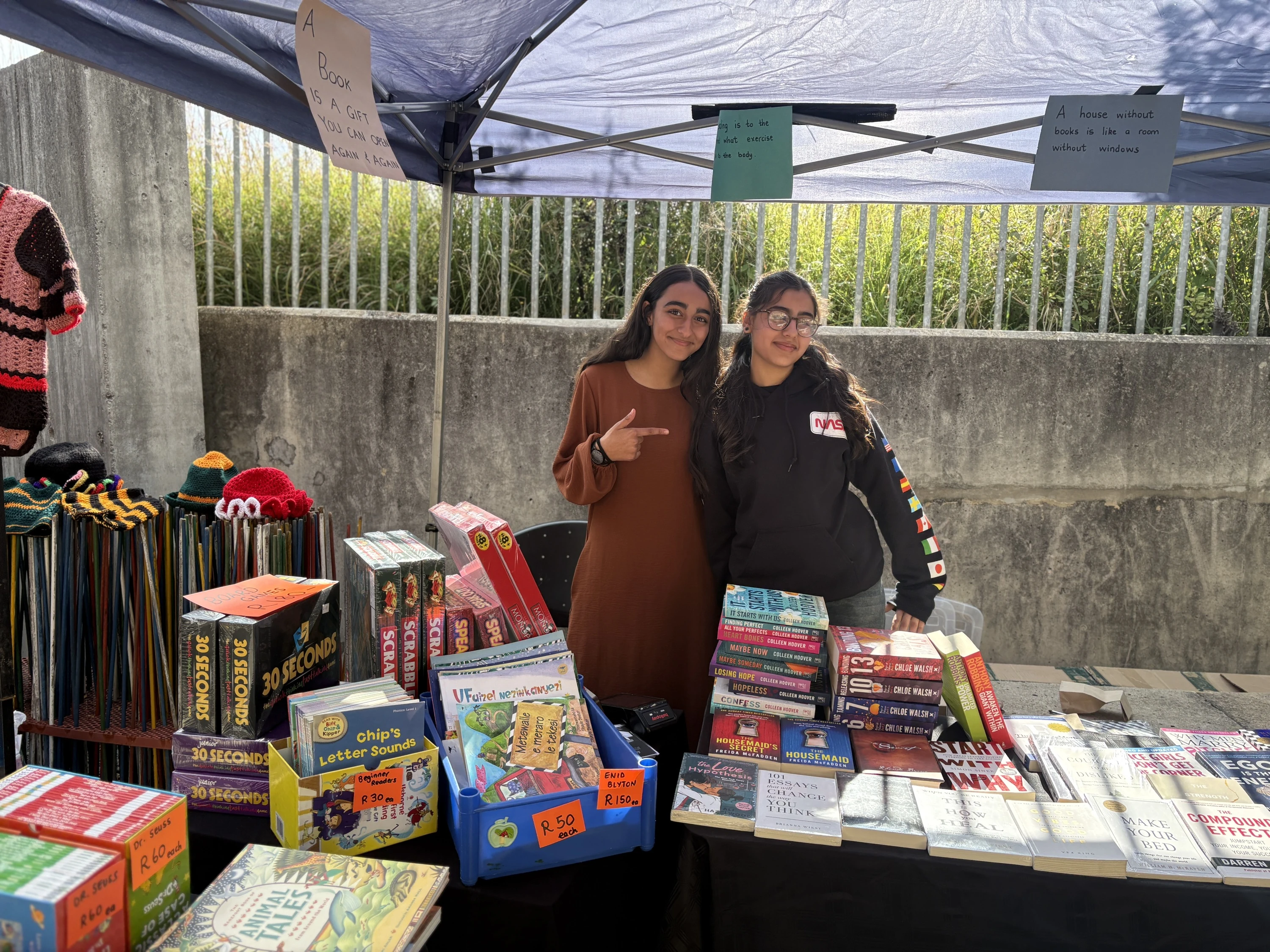Habiba Yousuf and Zainab Asif standing behind their table at Bookaholics stall in Johannesburg