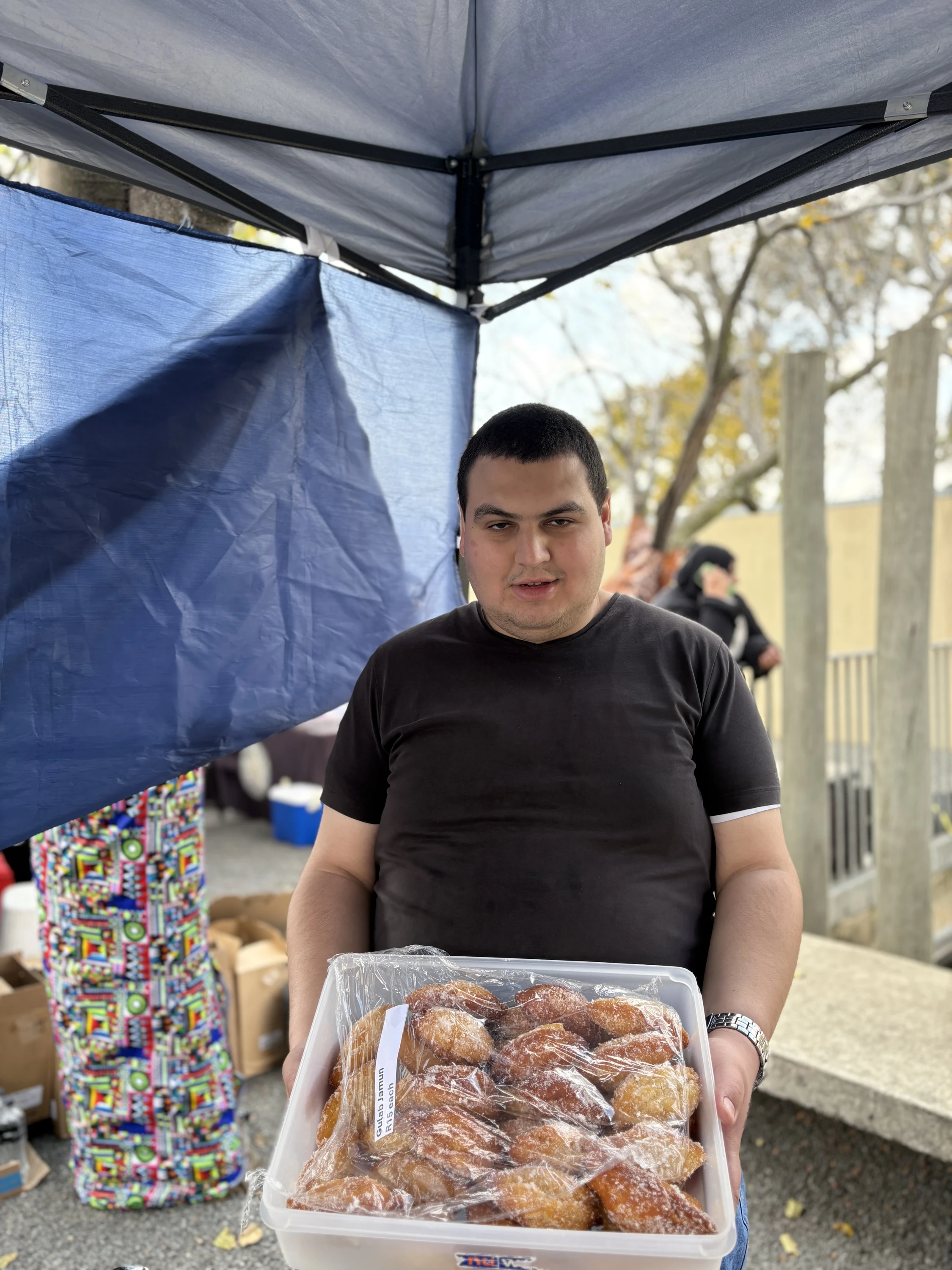 Irfan Genc holding a container with his delicious baked goodies at a stall in Johannesburg 