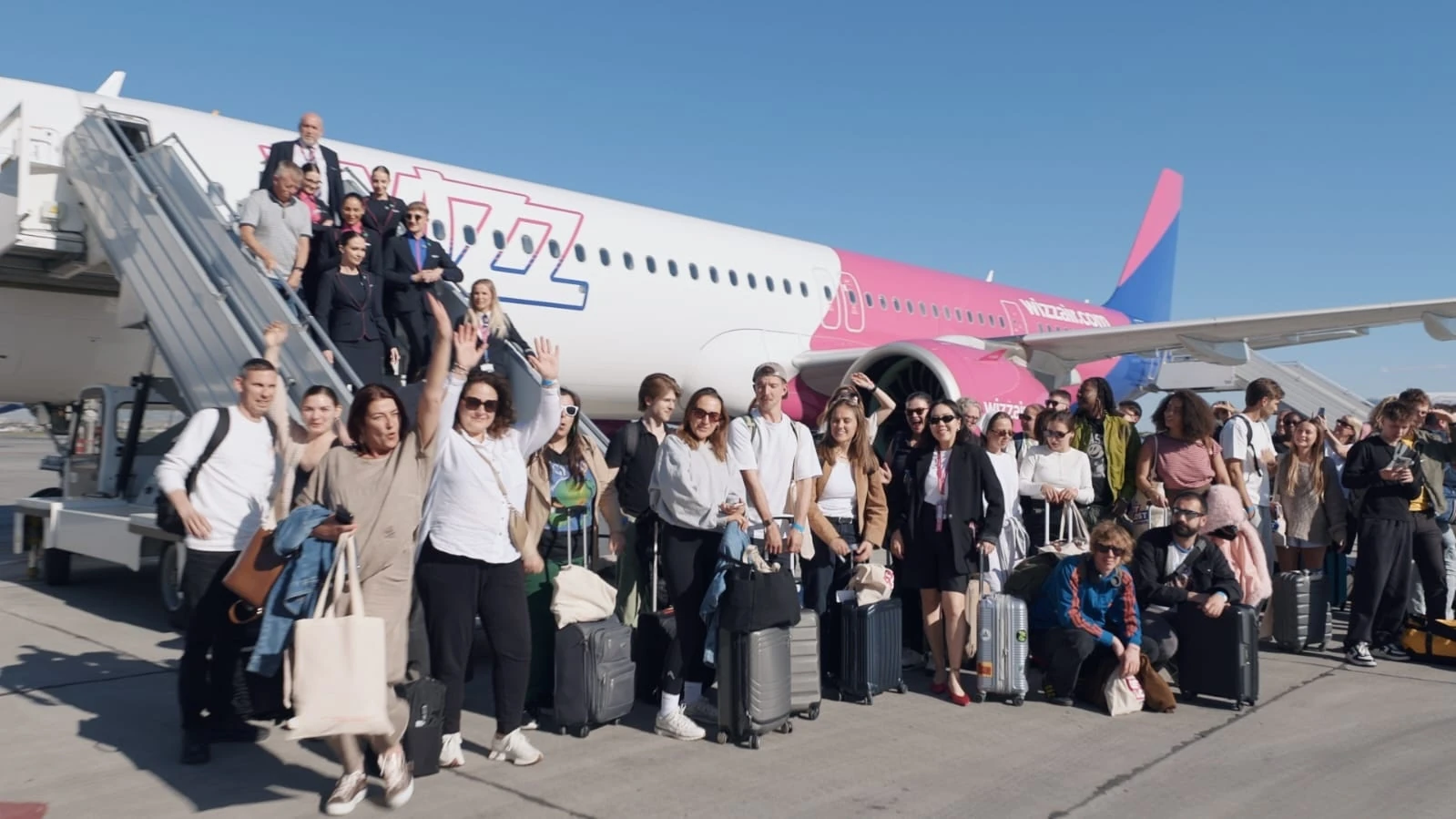 A crowd of people gather around an aeroplane