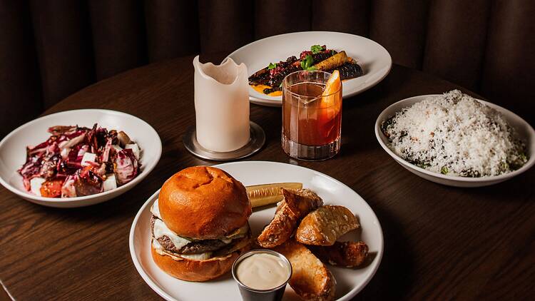 A variety of dishes and a cocktail on a table.