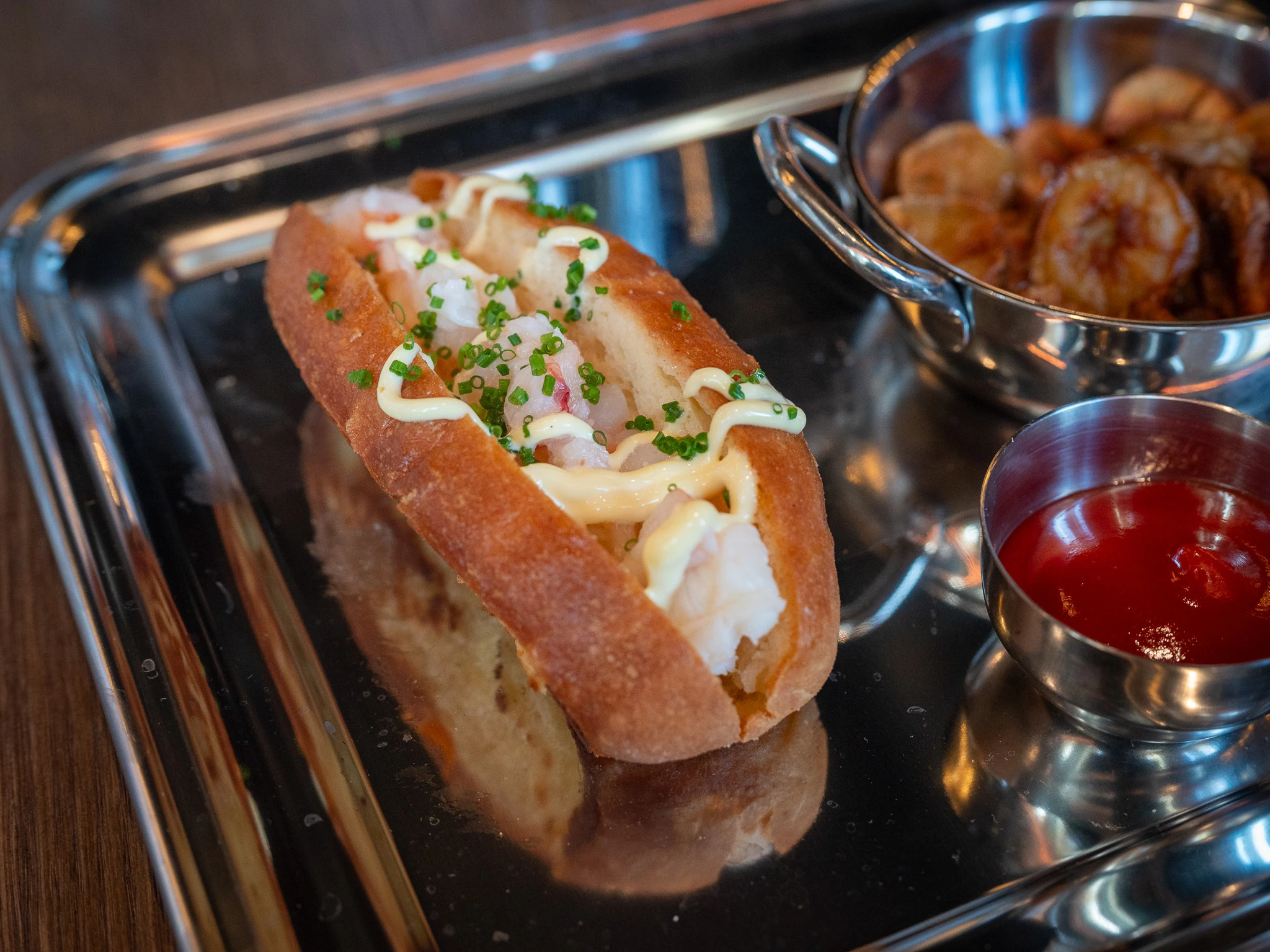 Lobster roll metallisella tarjottimella ravintolassa Fat Tony's Helsingiss&auml;