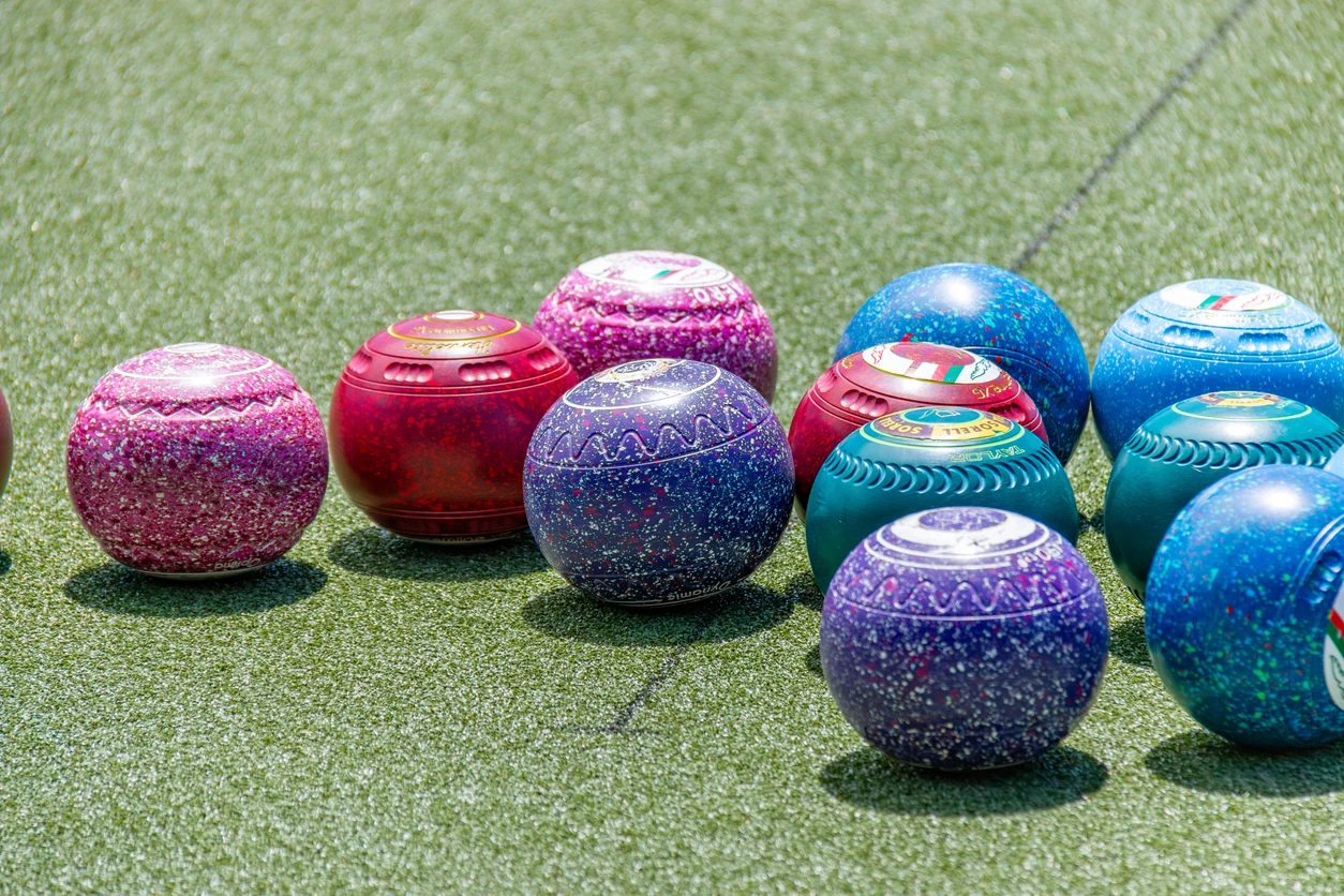 Colourful lawn bowls after a roll up on a bowling green in the sunshine