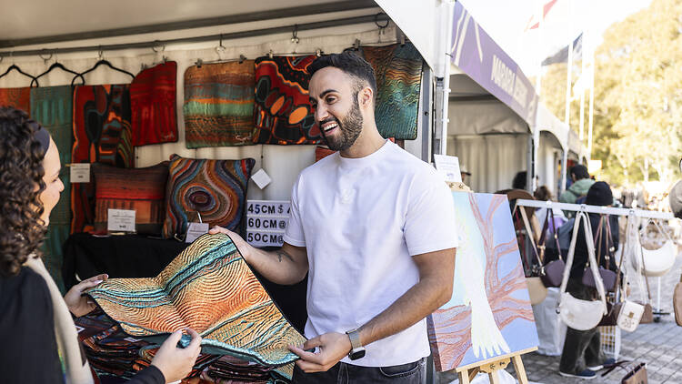 A man and woman holding a tapestry