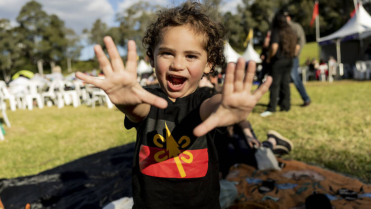 A kid wearing a First Nations shirt 