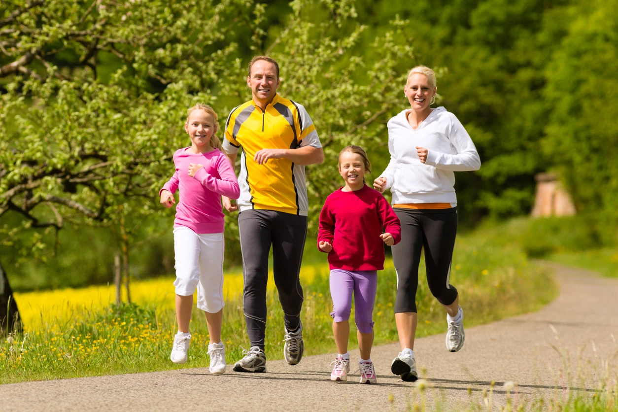 Family jogging for sport outdoors with the kids on summer day