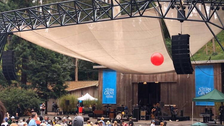 A wide shot of people standing under a large tent