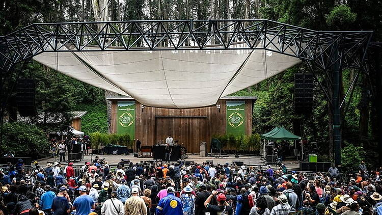 A wide shot of people standing under a large tent