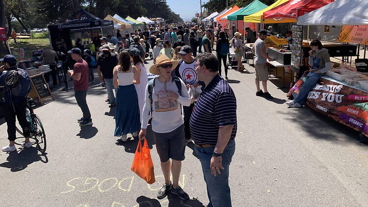 A wide shot of people shopping at an outdoor market
