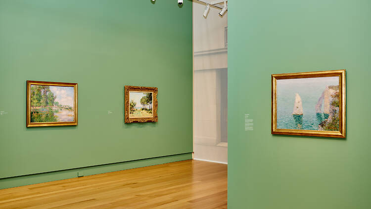 Art hanging in a green-walled gallery.