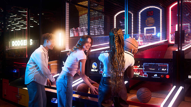 Archie Brothers QV Melbourne Thee people playing basketball at an arcade