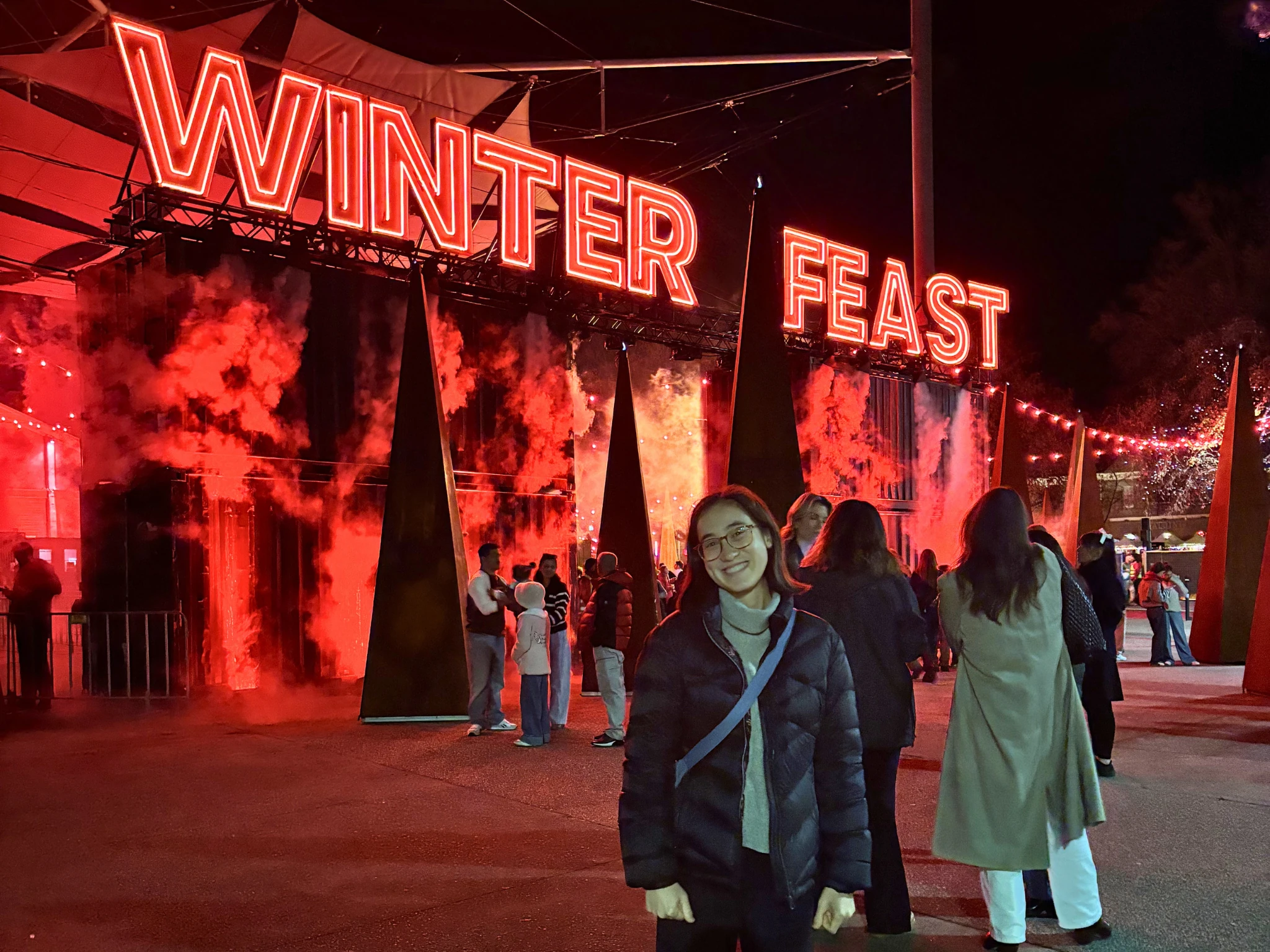 Girl standing in from of red winter feast sign