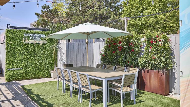 A beer garden with an umbrella-shaded table.