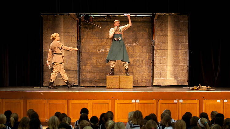 A wide shot of two actors performing onstage