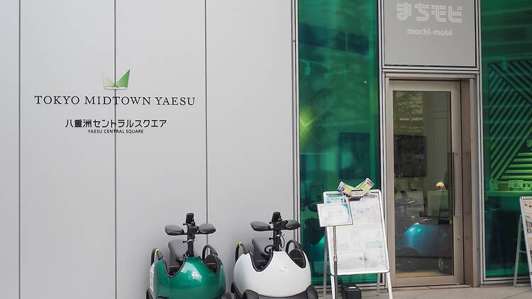 TOKYO, JAPAN - May 8, 2026: A Machi-Mobi center with rental Rodem vehicles parked outside in Tokyo Midtown Yaesu.