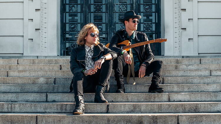 A wide shot of two men sitting in concrete steps