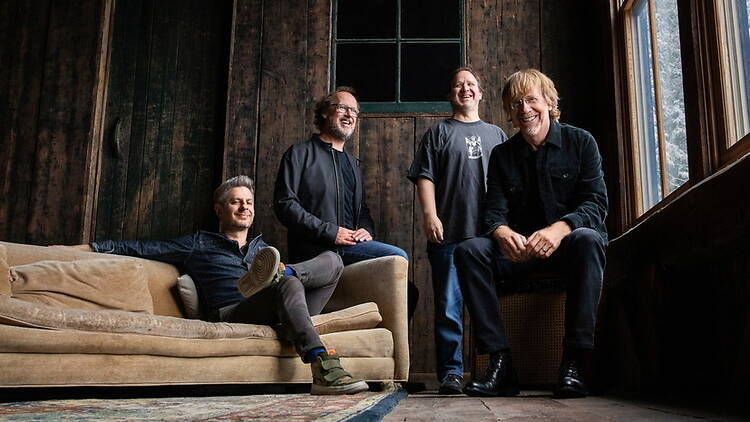 A wide shot of four musical artists in a room. A wide shot of four musical artists in a room.