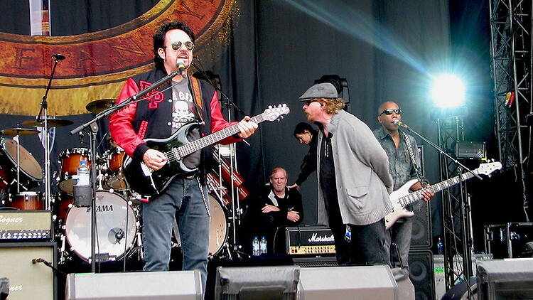 A wide shot of Toto singing on stage with band members behind A wide shot of Toto singing on stage with band members behind
