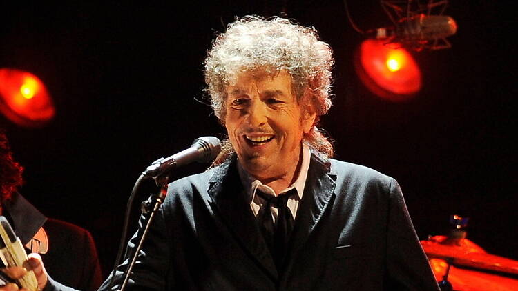 A close-up of Bob Dylan singing into a microphone. A close-up of Bob Dylan singing into a microphone.