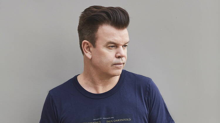 A medium close up shot of a person standing against a gray background A medium close up shot of a person standing against a gray background