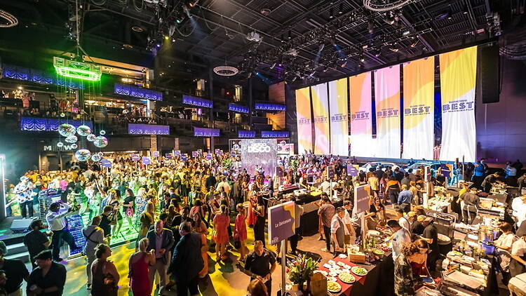Wide shot of people attending a large indoor event in a convention hall Wide shot of people attending a large indoor event in a convention hall