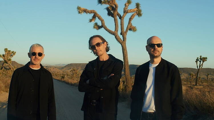 A close-up of Above & Beyond standing on a desert road. A close-up of Above & Beyond standing on a desert road.