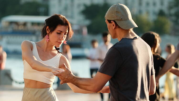 A close-up of a man and a woman dancing beside a river. A close-up of a man and a woman dancing beside a river.
