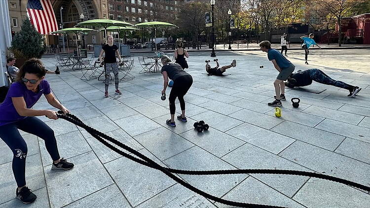 A wide shot of people exercising in an outdoor plaza. A wide shot of people exercising in an outdoor plaza.