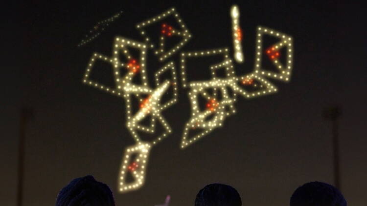 A wide shot of a drone light show in the night sky. A wide shot of a drone light show in the night sky.