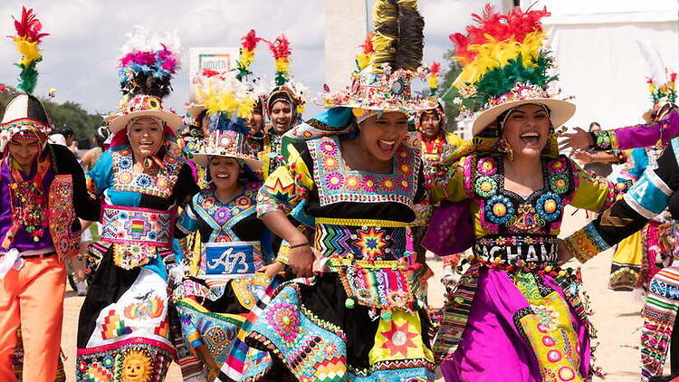 A wide shot of people dancing in colorful traditional costumes outdoors. A wide shot of people dancing in colorful traditional costumes outdoors.