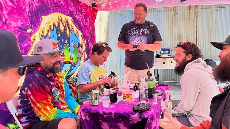 Wide shot of a group of men socializing around a table outdoors Wide shot of a group of men socializing around a table outdoors