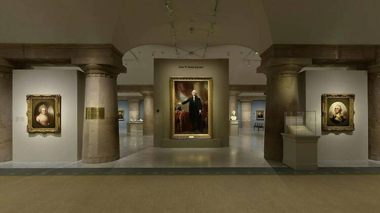 A wide shot of framed portraits displayed in a museum gallery