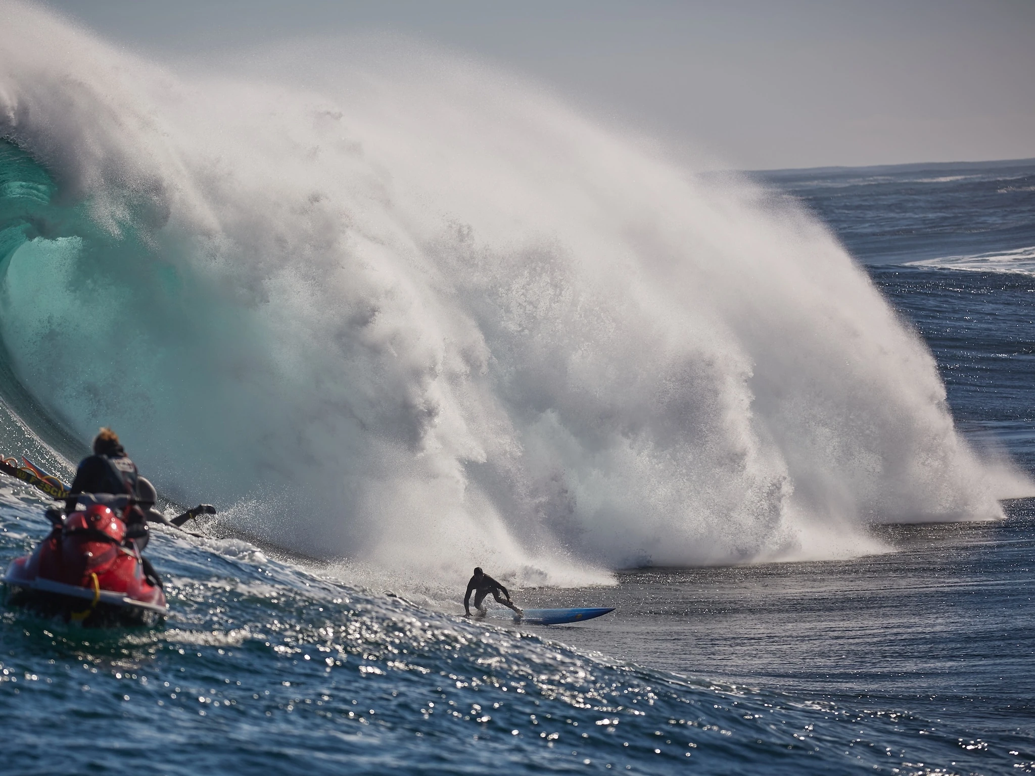 Surfers charging a bomb at Dungeons