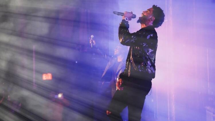 A close-up of a singer performing on a stage with a microphone A close-up of a singer performing on a stage with a microphone