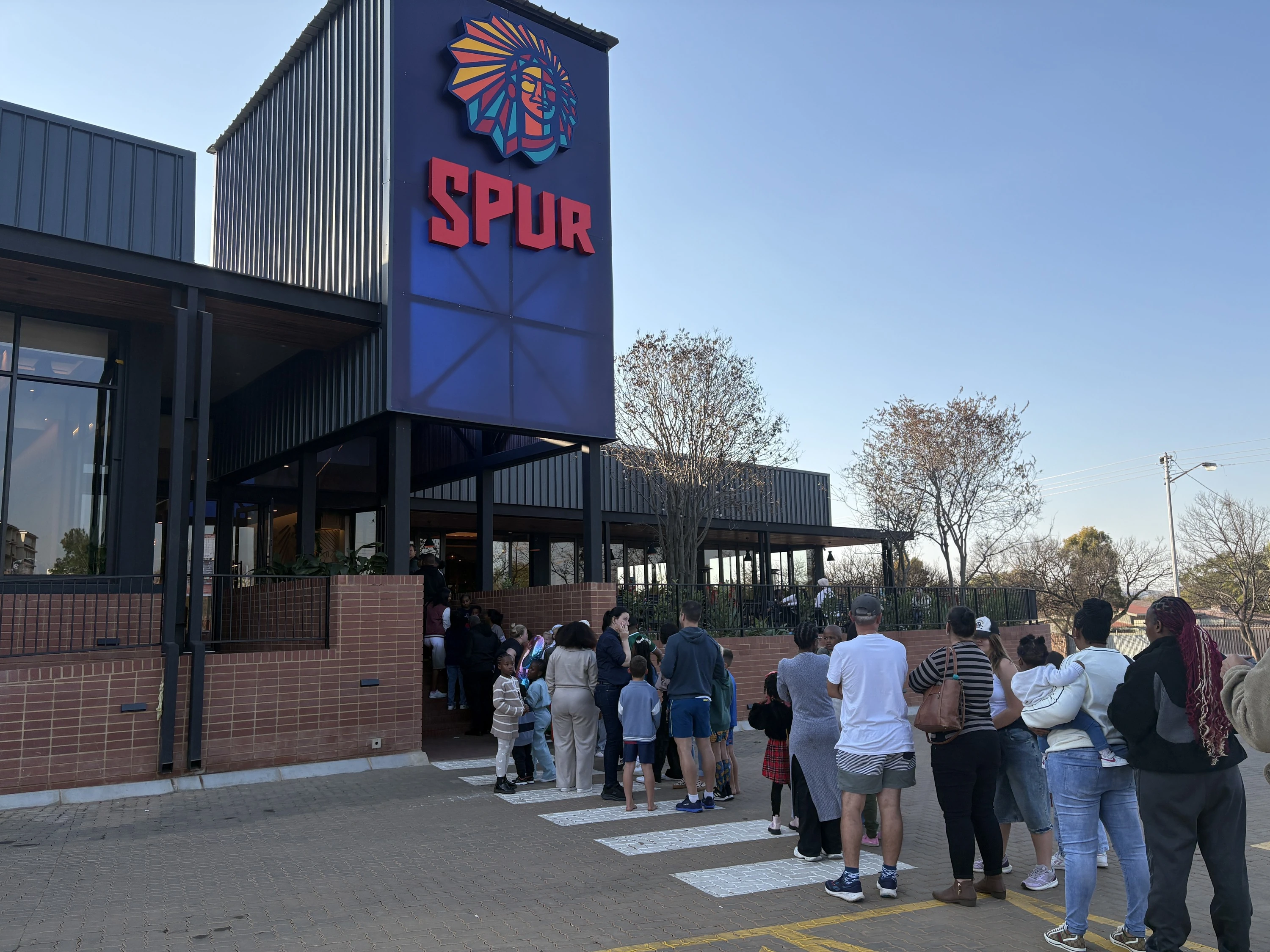 Long queue of people waiting outside Burning Arrow Spur in Queenswood