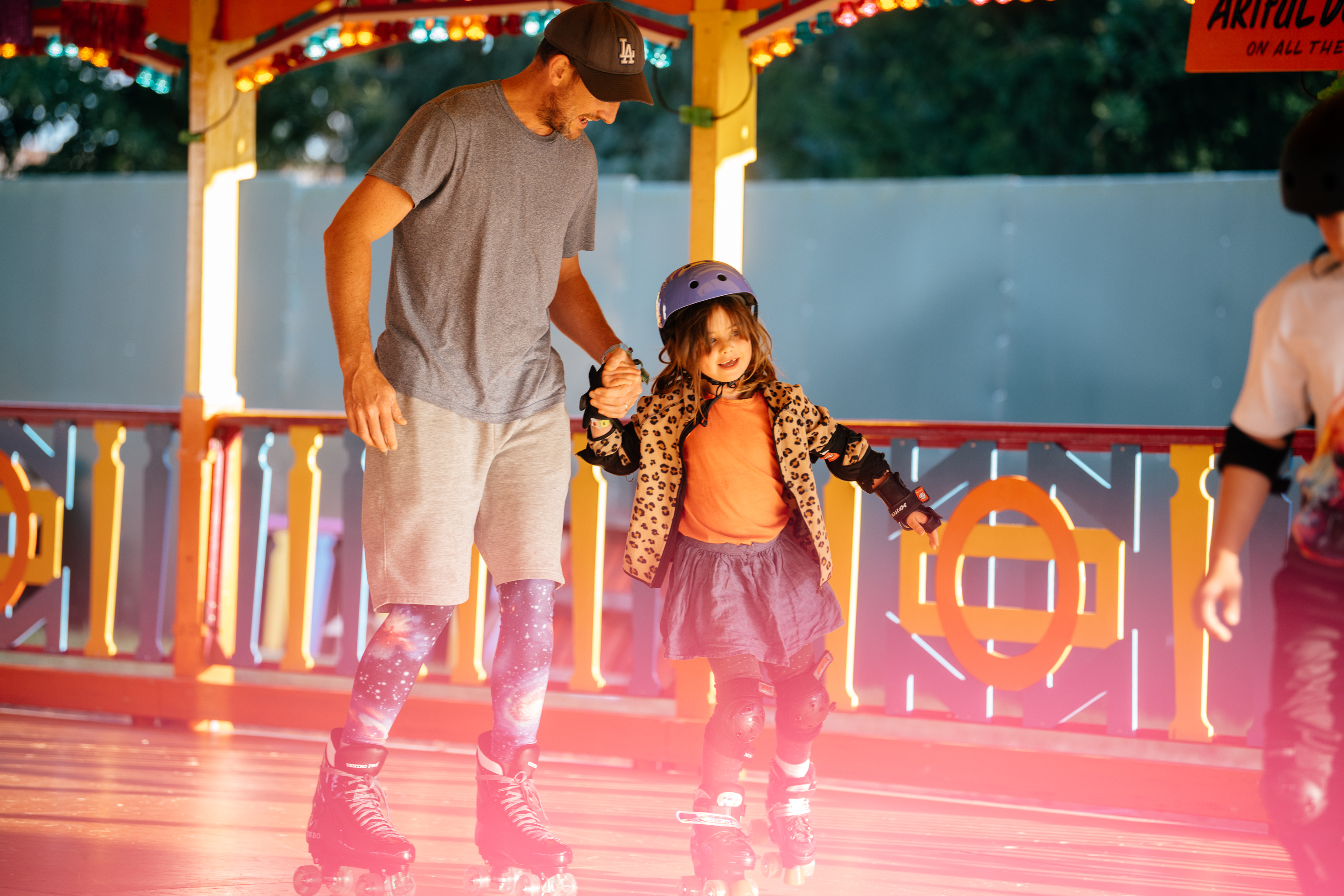 Dad and daughter rollerskating at Electric Summer